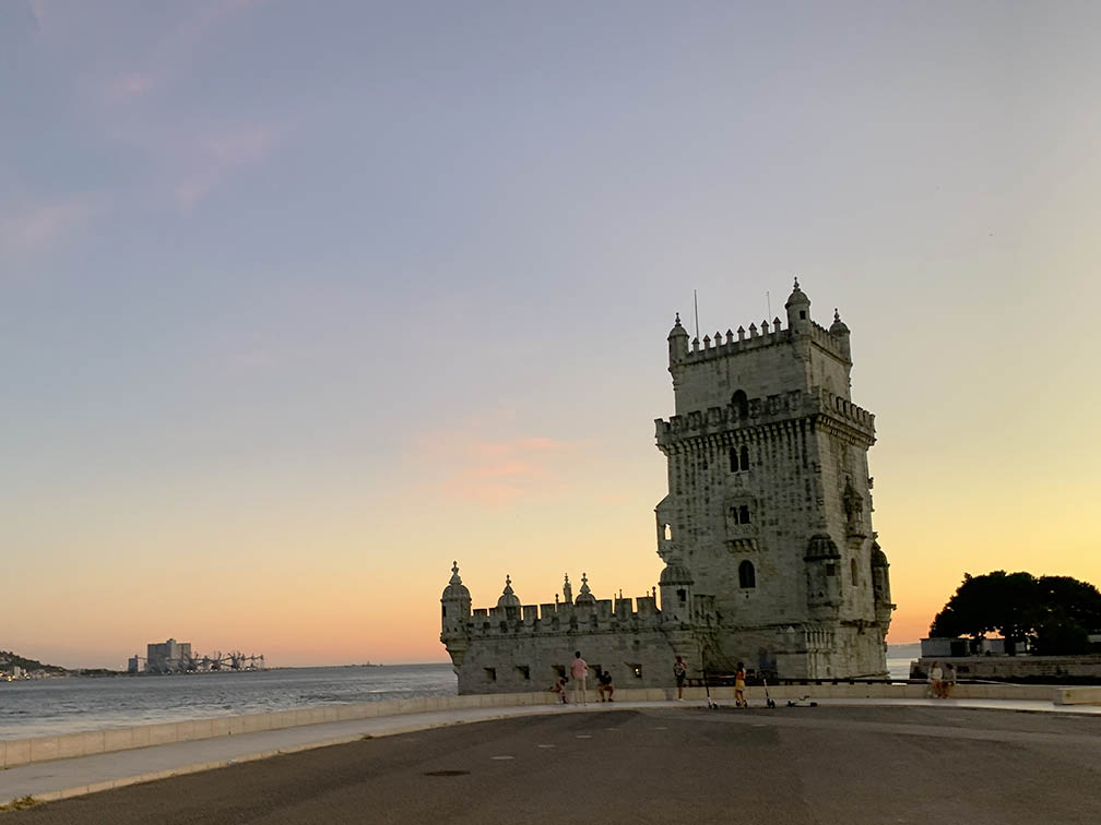 a torre de Belém com um pôr-do-sol ao fundo