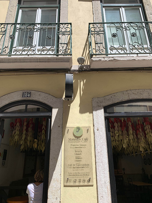 Eingang zum Brunch-Restaurant Stanislav Portugiesisches Gebäude mit gelber Fassade offene Fenster getrocknete Blumen an der Decke   