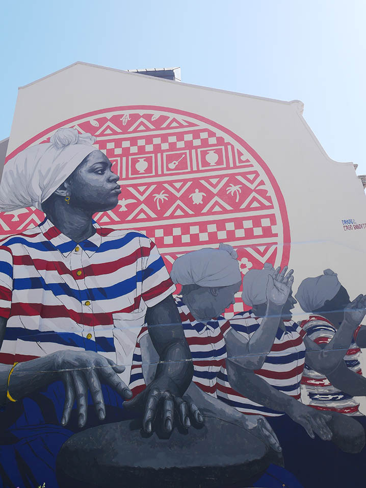 mural del grafitero Frederico Draw que representa a mujeres tocando un instrumento de percusión  