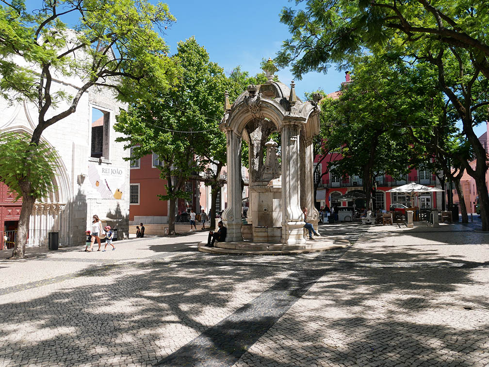 La plaza do Carmo con una fuente clásica y barroca en el centro, rodeada de jacarandas.