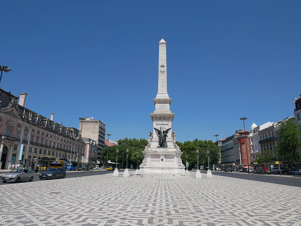 La plaza de los Restauradores está pavimentada en blanco y negro, formando líneas entrecruzadas con un obelisco en el centro que honra las batallas libradas durante la Guerra de la Restauración portuguesa de 1640.  