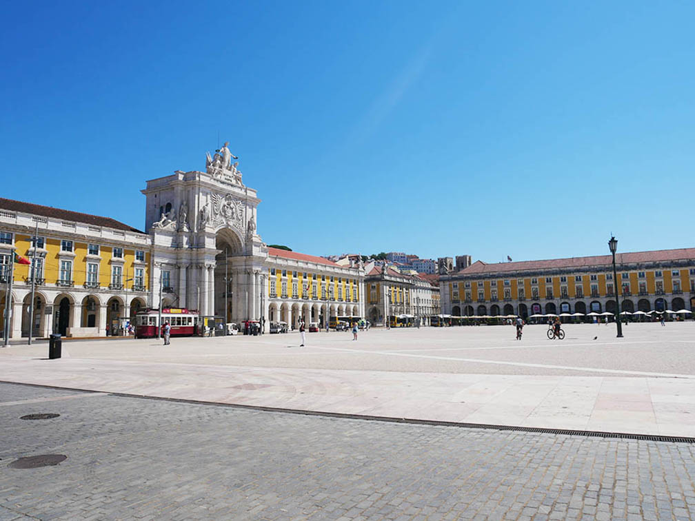 里斯本最大的广场--商业广场（Praça do Comércio）或贸易广场，周围是带有黄色拱门的建筑。